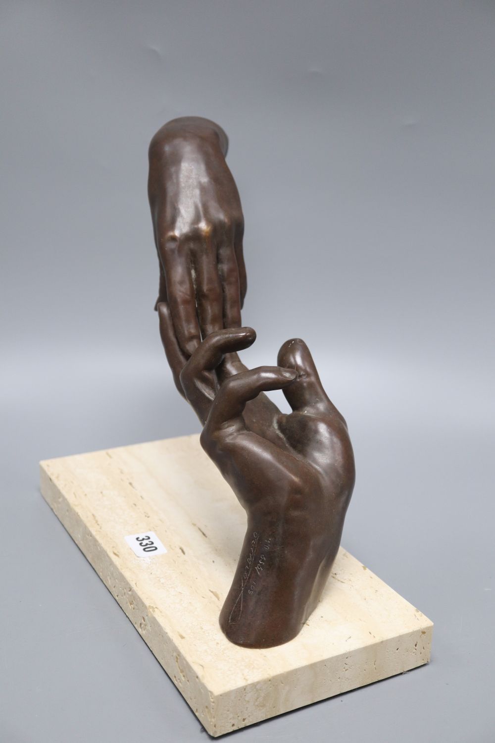 A modern American limited edition bronzed hand sculpture on a hardstone base, signed Lorenzo
